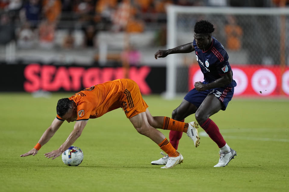 Houston Dynamo's Sebastián Ferreira (9) falls as Chicago Fire's Carlos Terán (23) defends during the second half of an MLS soccer game Saturday, June 25, 2022, in Houston. (AP Photo/David J. Phillip)