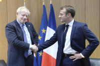 Britain's Prime Minister Boris Johnson poses with French President Emmanuel Macron, right, during a European Union leaders summit in Brussels, Belgium, Thursday Oct. 17, 2019. Britain and the European Union reached a new tentative Brexit deal on Thursday, hoping to finally escape the acrimony, divisions and frustration of their three-year negotiation. (Johanna Geron/Pool via AP)