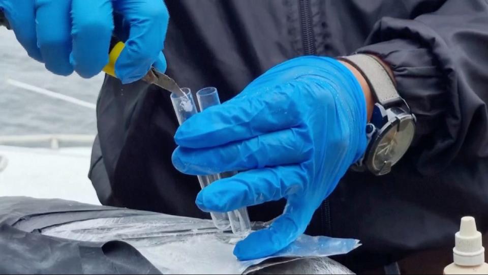 A Colombian navy officer tests some of the cocaine that was seized from aboard the submarine.