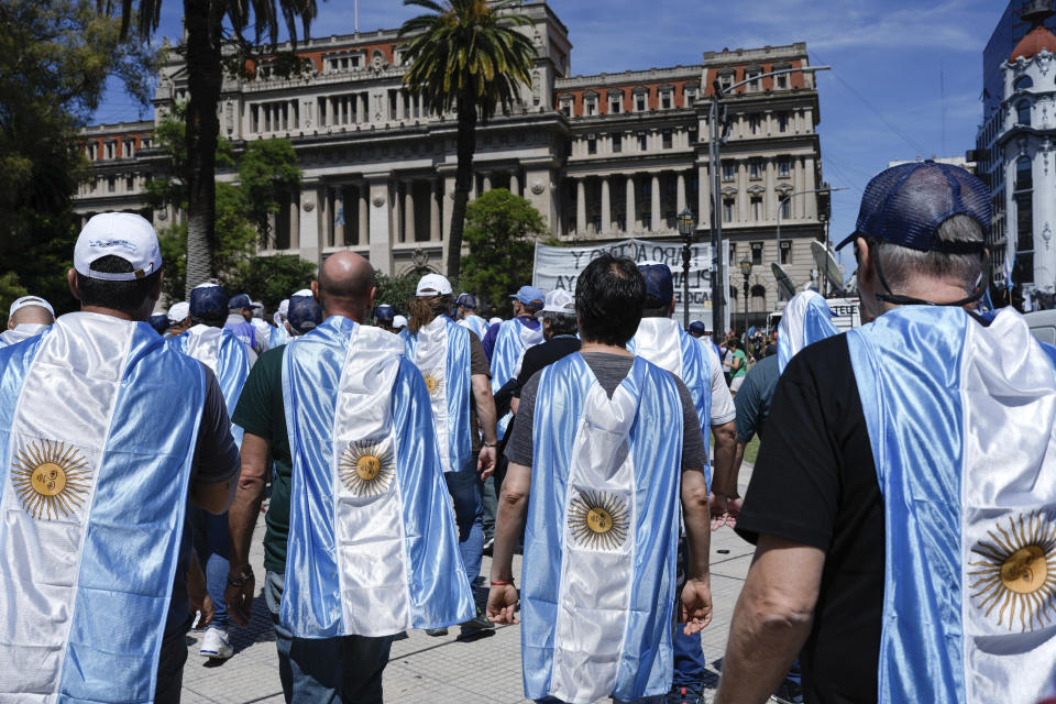 Protesters wearing national flags, rally against the economic reforms of President Javier Milei outside the Supreme Court as labor unions legally challenge the measures, in Buenos Aires, Argentina, Dec. 27, 2023. (AP Photo/Rodrigo Abd)