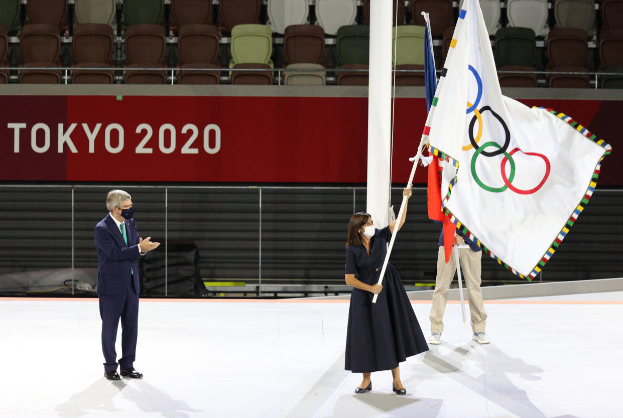 TOKYO, JAPAN - AUGUST 8, 2021:Paris Mayor Anne Hidalgo (R front) receives the Olympic flag from IOC President Thomas Bach (L) during the closing ceremony of the 2020 Summer Olympic Games at the Japan National Stadium (a.k.a the Olympic Stadium). The Olympic Games were held amid the COVID-19 pandemic. The closing ceremony features live and pre-recorded elements. Sergei Bobylev/TASS (Photo by Sergei Bobylev\TASS via Getty Images)