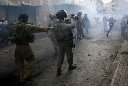 Palestinians run away from Israeli troops during clashes following a protest demanding Israel to return the dead bodies of Palestinians who allegedly stabbed Israelis, in the West Bank city of Hebron October 27, 2015. REUTERS/Mussa Qawasma