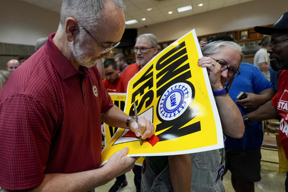 UAW president Shawn Fain signs an autograph for Volkswagen automobile plant employee Rachel Gleeson after workers voted to join the union Friday, April 19, 2024, in Chattanooga, Tenn. (AP Photo/George Walker IV)