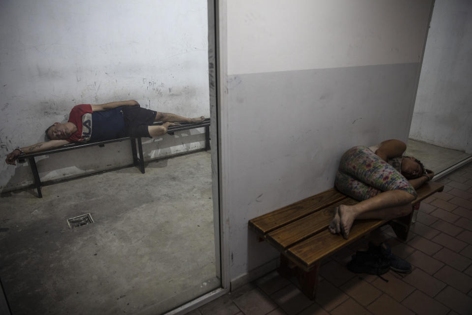 Detainees sleep overnight at a police station after getting arrested for fighting in the street at night under the influence of drugs in Rosario, Argentina, Sunday, Dec. 5, 2021. The city of some 1.3 million people has high levels of poverty and crime, where violence between gangs who seek to control turf and drug markets has helped fill its prisons. (AP Photo/Rodrigo Abd)