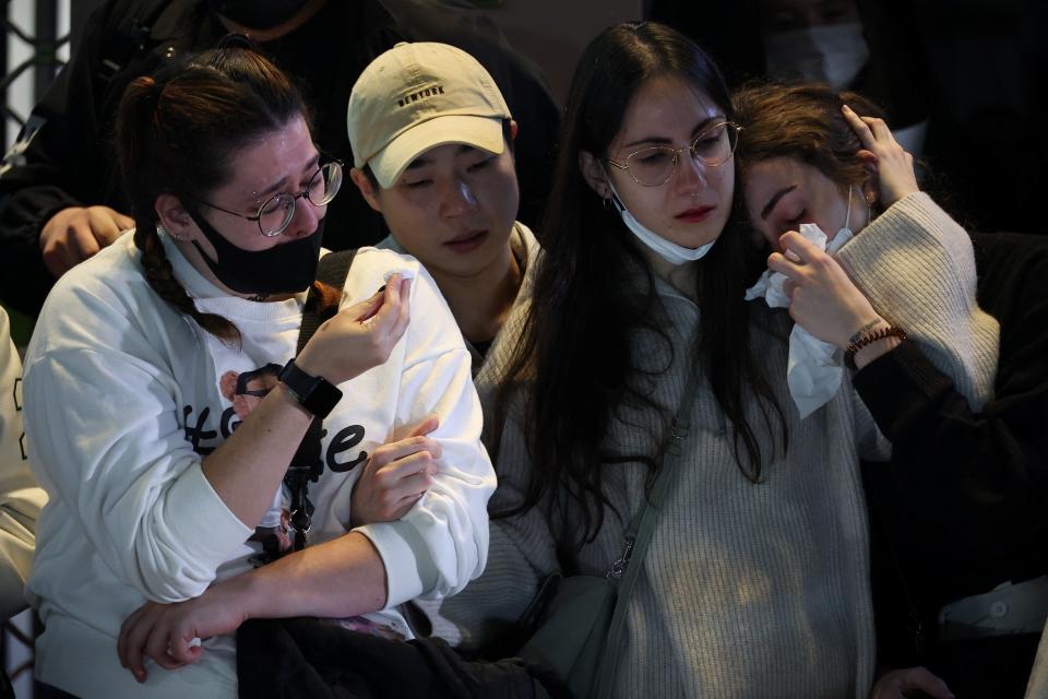 People react near the scene of a crowd crush that happened during Halloween festivities, in Seoul, South Korea (REUTERS)
