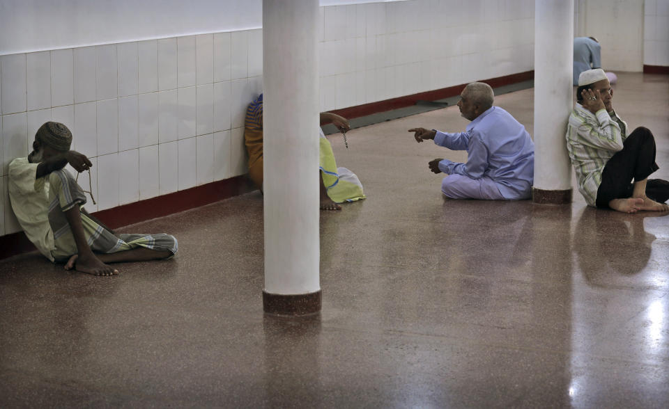 FILE - In this Friday, April 26, 2019 file photo, Sri Lankan Muslims talk and pray before the start of Friday prayers inside a mosque, in Colombo, Sri Lanka. Authorities had told Muslims to pray at home rather than attend communal Friday prayers that are the most important religious service for the faithful. At one mosque in Colombo where prayers were still held, police armed with Kalashnikov assault rifles stood guard outside. (AP Photo/Manish Swarup, File)