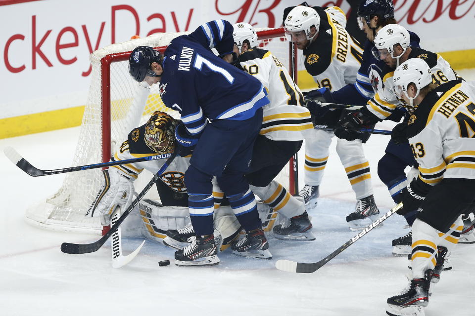 Boston Bruins goaltender Tuukka Rask (40) keeps Winnipeg Jets' Dmitry Kulikov (7) away from the puck during the first period of an NHL hockey game Friday, Jan. 31, 2020, in Winnipeg, Manitoba. (John Woods/The Canadian Press via AP)