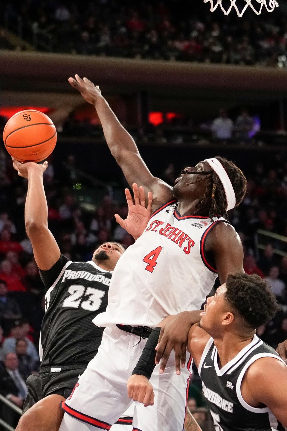St. John's forward O'Mar Stanley (4) blocks the shot of Providence forward Bryce Hopkins (23) during the first half of an NCAA college basketball game, Saturday, Feb. 11, 2023 in New York. (AP Photo/Bryan Woolston)