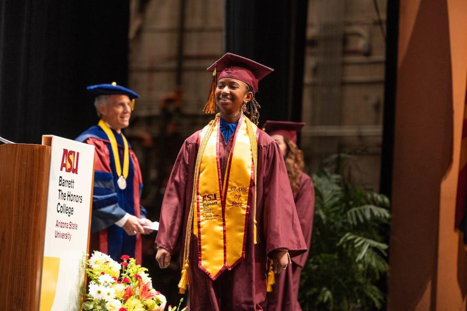 15-year-old Alena McQuarter crosses the stage at Arizona State University's Barrett Honors College convocation on Monday, Dec. 11, 2023.