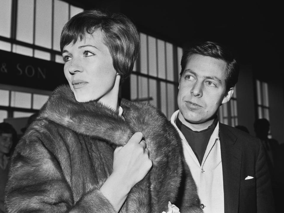 Julie Andrews with her husband, set and costume designer Tony Walton (1934 - 2022) at London Airport (later Heathrow), UK, 10th September 1963