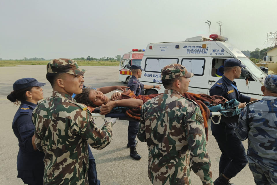 A woman airlifted from an earthquake-affected area is carried on a stretcher in Nepalgunj, Nepal, Saturday, Nov. 4, 2023. A strong earthquake has shaken northwestern Nepal, and officials say more than 100 people are dead and dozens more injured as rescuers search mountain villages. (AP Photo/Krishna Adhikari)