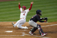 Los Angeles Angels shortstop Jose Iglesias (4) slides in to home plate to score off of a double hit by Juan Lagares during the second inning of a baseball game against the Cleveland Indians Monday, May 17, 2021, in Los Angeles. (AP Photo/Ashley Landis)