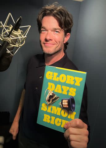 <p>Courtesy of Hachette Audio</p> John Mulaney holds a copy of 'Glory Days' by Simon Rich