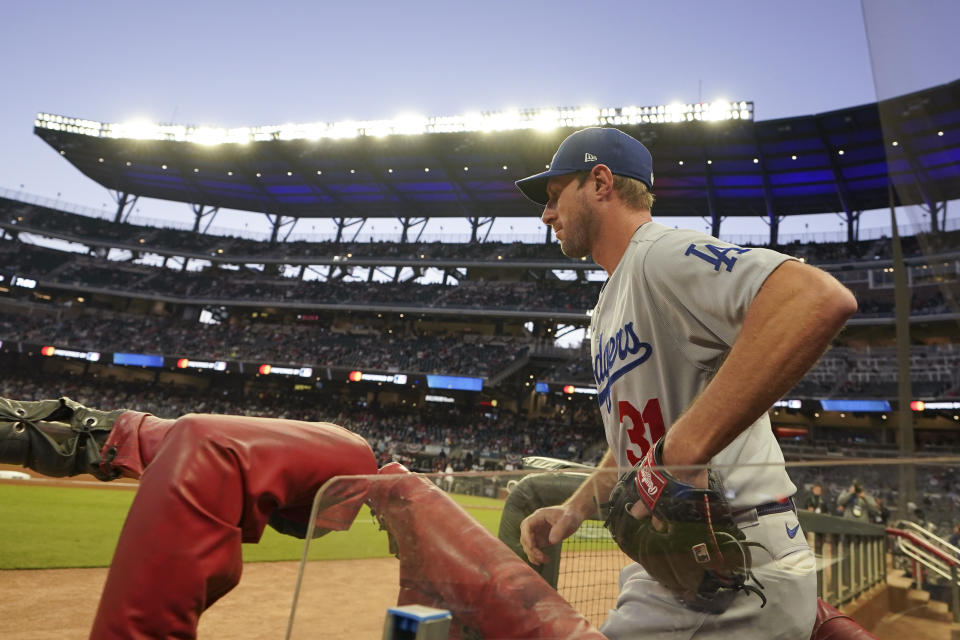 Los Angeles Dodgers starting pitcher Max Scherzer heads out of the dugout before Game 2 of baseball's National League Championship Series between the Atlanta Braves and the Los Angeles Dodgers Sunday, Oct. 17, 2021, in Atlanta. (AP Photo/Brynn Anderson)