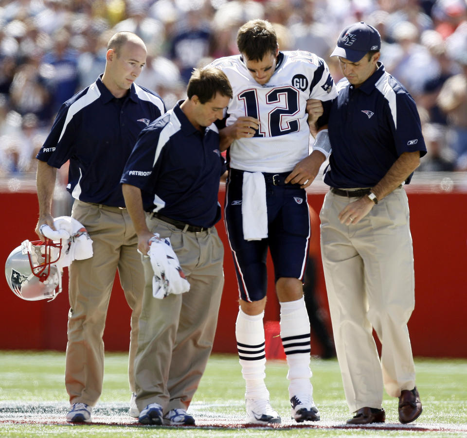 FILE - New England Patriots quarterback Tom Brady (12) is helped off the field by medical personnel after he was hit while throwing the ball during the first quarter of the team's NFL football game against the Kansas City Chiefs on Sept. 7, 2008, in Foxborough, Mass. Brady tore his ACL on a hit in the first quarter by Bernard Pollard that led to a rule change prohibiting low hits on QBs. But that came too late to help New England.(AP Photo/Winslow Townson, File)