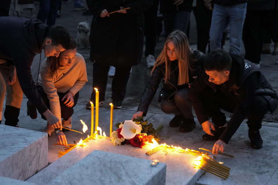 People light candles for the victims near the Vladislav Ribnikar school in Belgrade, Serbia, Wednesday, May 3, 2023. Police say a 13-year-old who opened fire at his school drew sketches of classrooms and made a list of people he intended to target. He killed eight fellow students and a school guard before being arrested. (AP Photo/Darko Vojinovic)