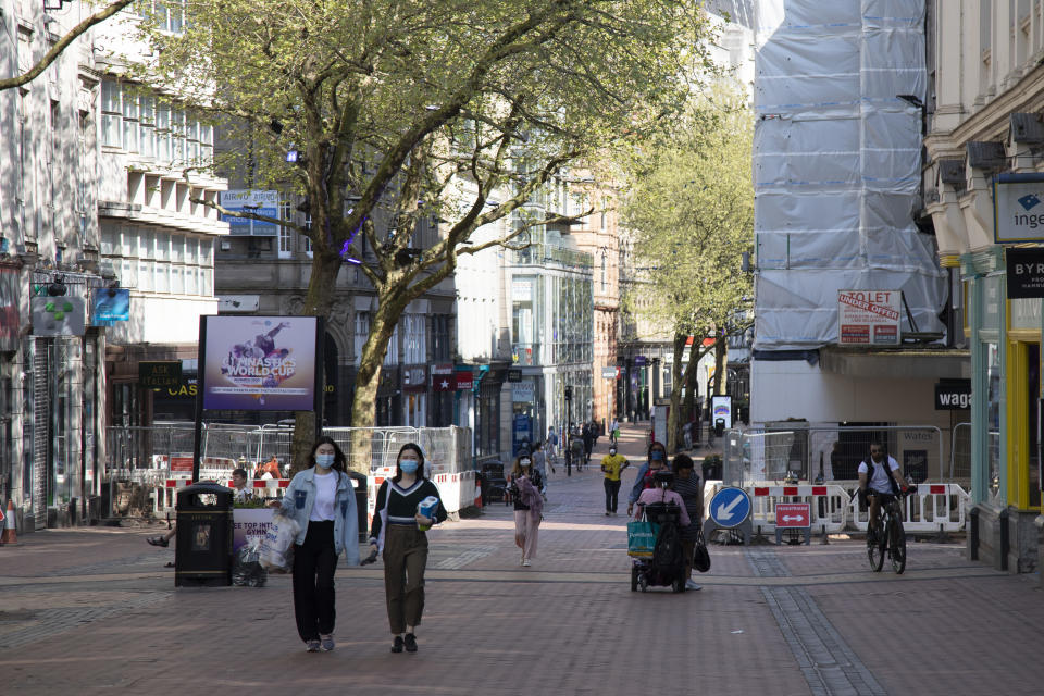 People wearing face masks in Birmingham city centre eerily quiet and deserted on New Street, one of the normally busy shopping areas, under lockdown due to Coronavirus on 24th April 2020 in Birmingham, England, United Kingdom. Coronavirus or Covid-19 is a new respiratory illness that has not previously been seen in humans. While much or Europe has been placed into lockdown, the UK government has extended stringent rules as part of their long term strategy, and in particular 'social distancing', which has left usually bustling areas like a ghost town. (photo by Mike Kemp/In PIctures via Getty Images)