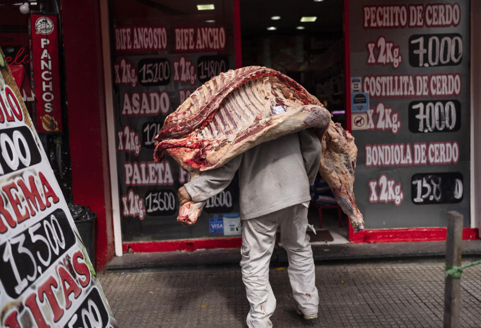 A seller delivers a beef carcass to a butcher shop in Buenos Aires, Argentina, April 10, 2024. President Javier Milei's plan to slash spending has encountered resistance in a nation where annual inflation tops 276%. (AP Photo/Rodrigo Abd)