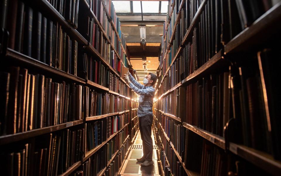 Chung Hoon arranges books in the rear book stacks at the London Library - Dominic Lipinski/PA Wire