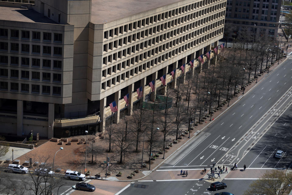 The FBI building surrounded by sparse vehicle and pedestrian traffic.