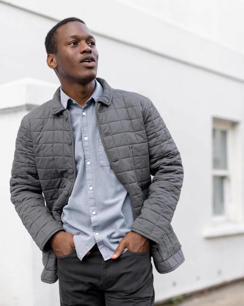 gray quilted jacket worn open over a blue shirt