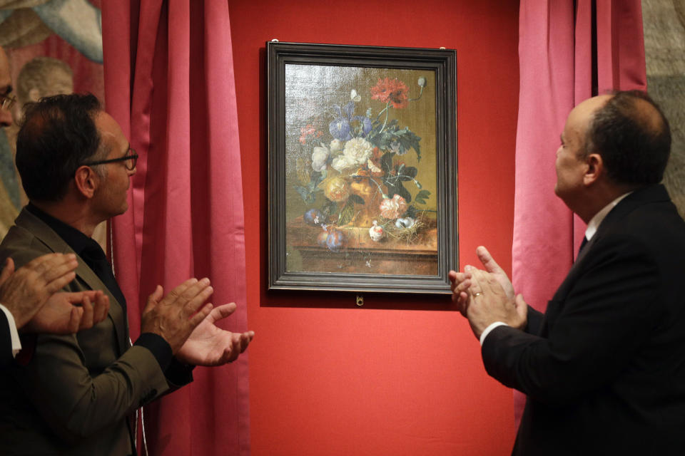 German Foreign Minister Heiko Mass, left, and Italian Culture Minister Alberto Bonisoli watch the unveiling of the "Vase of Flowers" painting by Jan van Huysum, at the Pitti Palace, part of the Uffizi Galleries, in Florence, Italy, Friday, July 19, 2019. Germany returned the Dutch still-life after it was stolen by Nazi troops during WWII. (AP Photo/Gregorio Borgia)