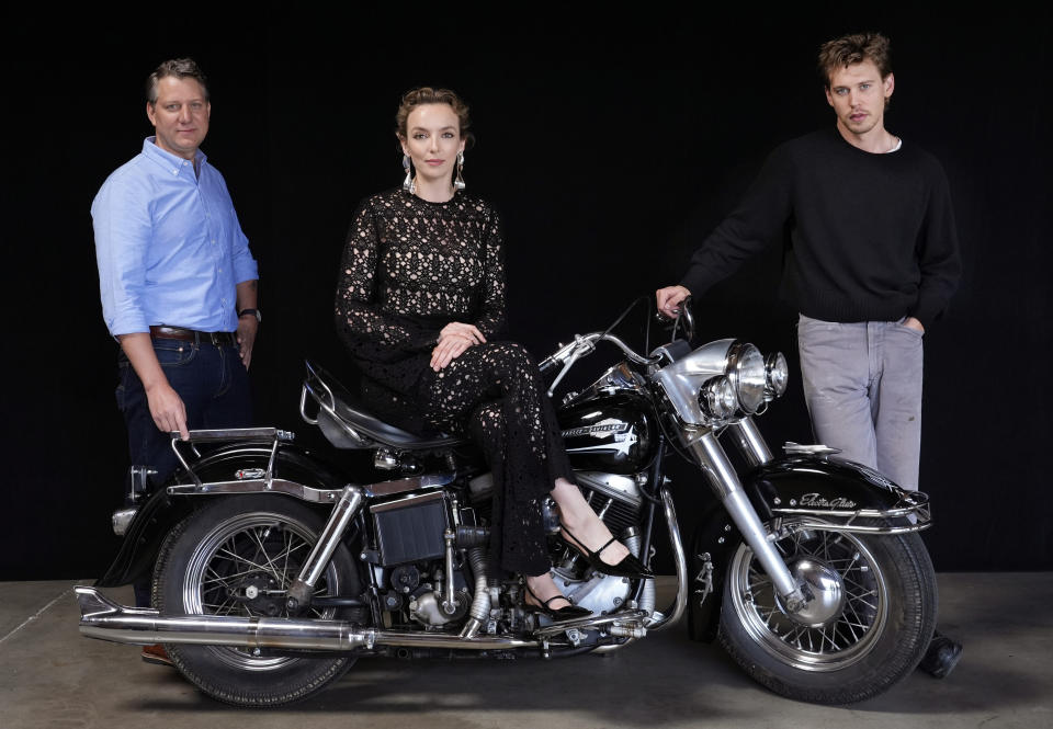 Jeff Nichols, left, writer/director of "The Bikeriders," poses with cast members Austin Butler, center, and Jodie Comer, Thursday, May 30, 2024, in Los Angeles. The motorcycle is a 1965 Harley Davidson Pan Head that Butler rode in the film. (AP Photo/Chris Pizzello)