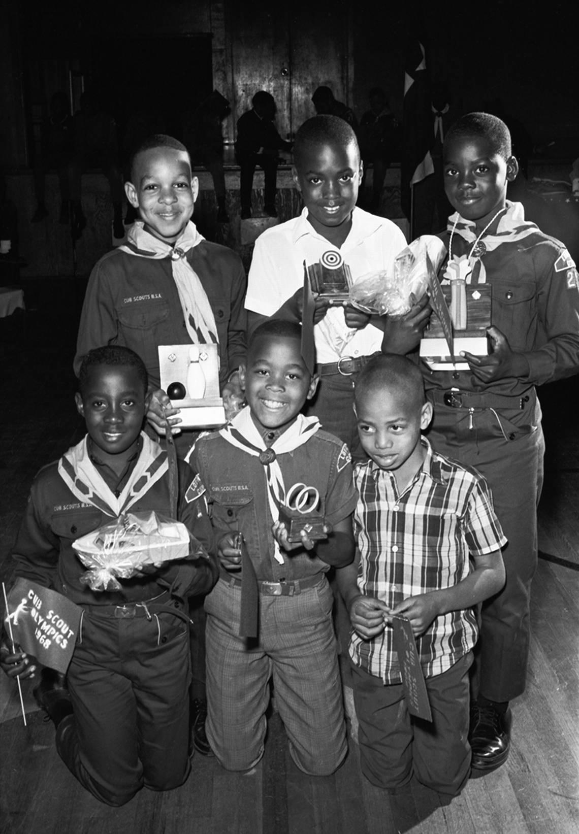 March 2, 1968: A group of children at the 1968 Cub Scout Olympics, held by the Woodbine Trail District Longhorn Council of the Boy Scouts, holding flags and various trophies. The event was held in Harmon Recreation Center in Fort Worth and was attended by about 100 cub and boy scouts. Cub Scout Pack 231, represented by Kirkpatrick Elementary school students Dale Brown, 10, Anthony Earle, 9, and Marcus Jones, 9, won the hoop race. Arbra King, 10, won the bowling competition and Robert Knox, 11, won the putting competition. Ron Heflin/Fort Worth Star-Telegram archive/UT Arlington Special Collections