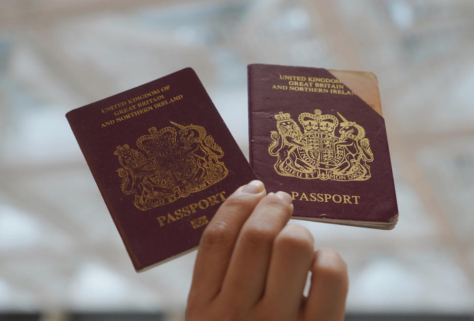 A protester holds up the British National (Overseas) passports in a shopping mall during a protest against China's national security legislation for the city, in Hong Kong, Monday, June 1, 2020. The mouthpiece of China's ruling Communist Party says U.S. moves to end some trading privileges extended to Hong Kong grossly interfere in China's internal affairs and are doomed to fail. (AP Photo/Vincent Yu)