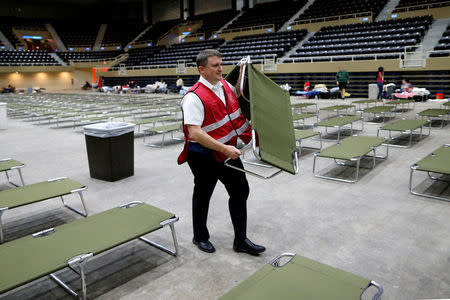 A volunteer with the Salvation Army sets up a cot in the Lake Charles Civic Center in preparation for Tropical Storm Harvey in Lake Charles, Louisiana, U.S., on August 29, 2017. REUTERS/Jonathan Bachman