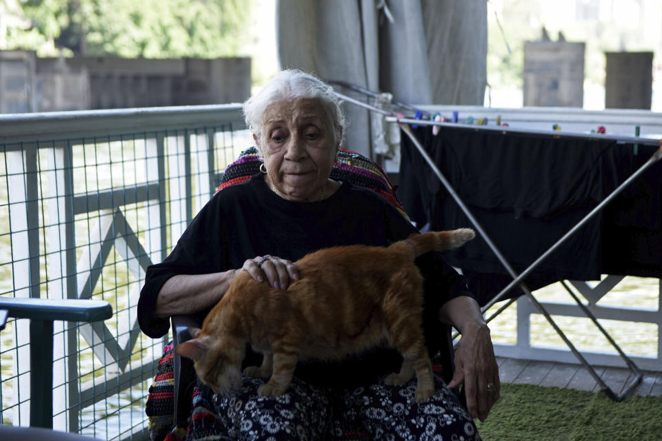 Ikhlas Helmy, an 88-year-old owner of a houseboat in Cairo, Egypt, sits on the veranda on June 27, 2022. A government push to remove the string of houseboats from Cairo’s Nile banks has dwindled their numbers from a several dozen to just a handful. Helmy stands to evicted, and the boat moved or demolished. The tradition of living on the Nile River dates back to the 1800s, and the removal of the boats has drawn criticism in Egypt. The government says it plans to develop the waterfront. (AP Photo/Tarek Wagih)