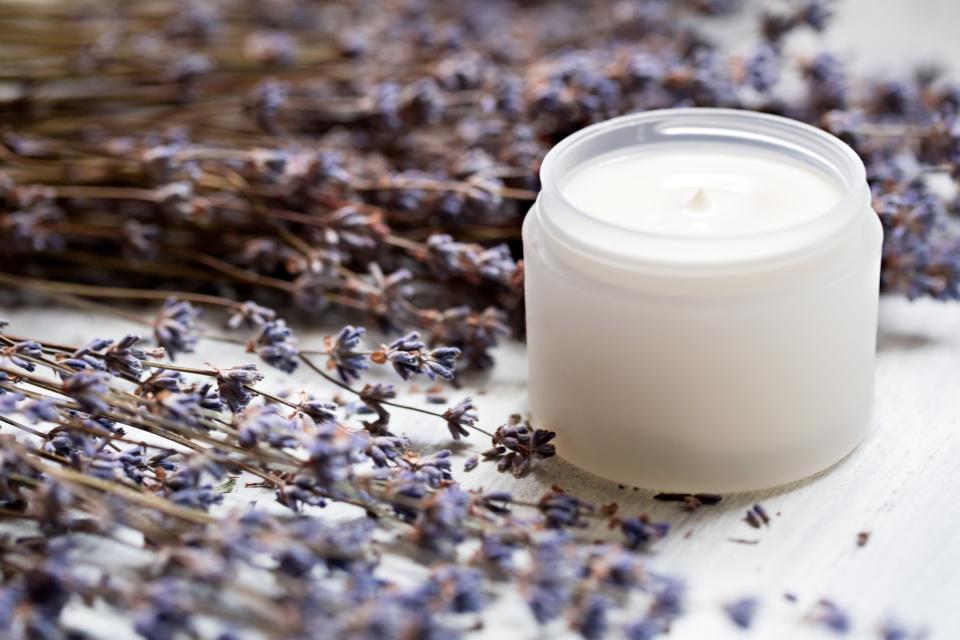 Facial moisturizer surrounded by lavender.