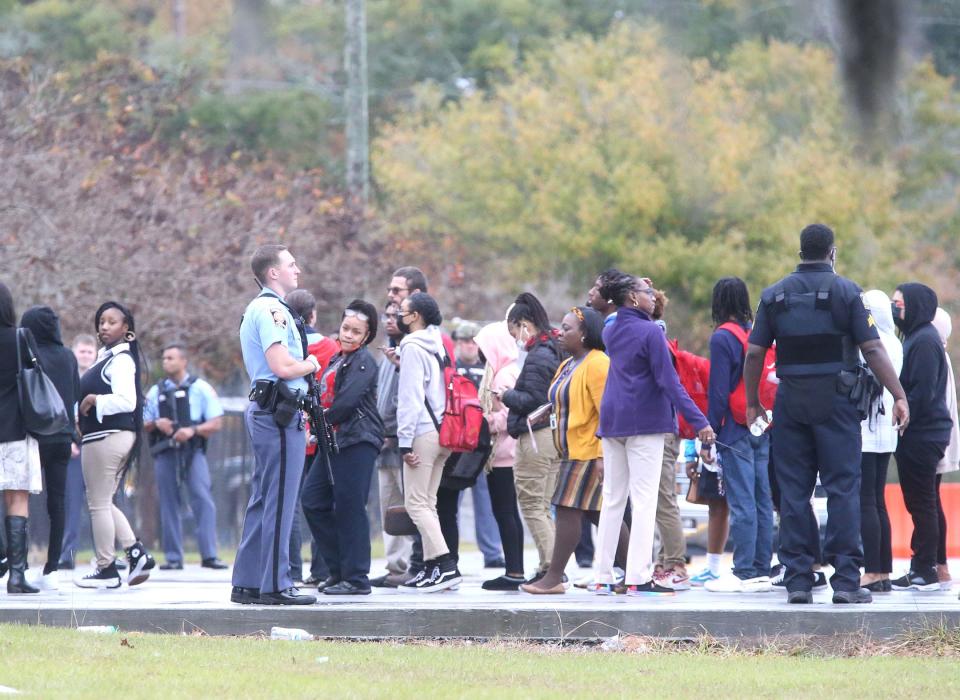 Armed officers stand along the sidewalk as students are escorted from the stadium to the gym on Wednesday November 30, 2022  during a lockdown due to rumors of a mass shooting at Savannah High School.