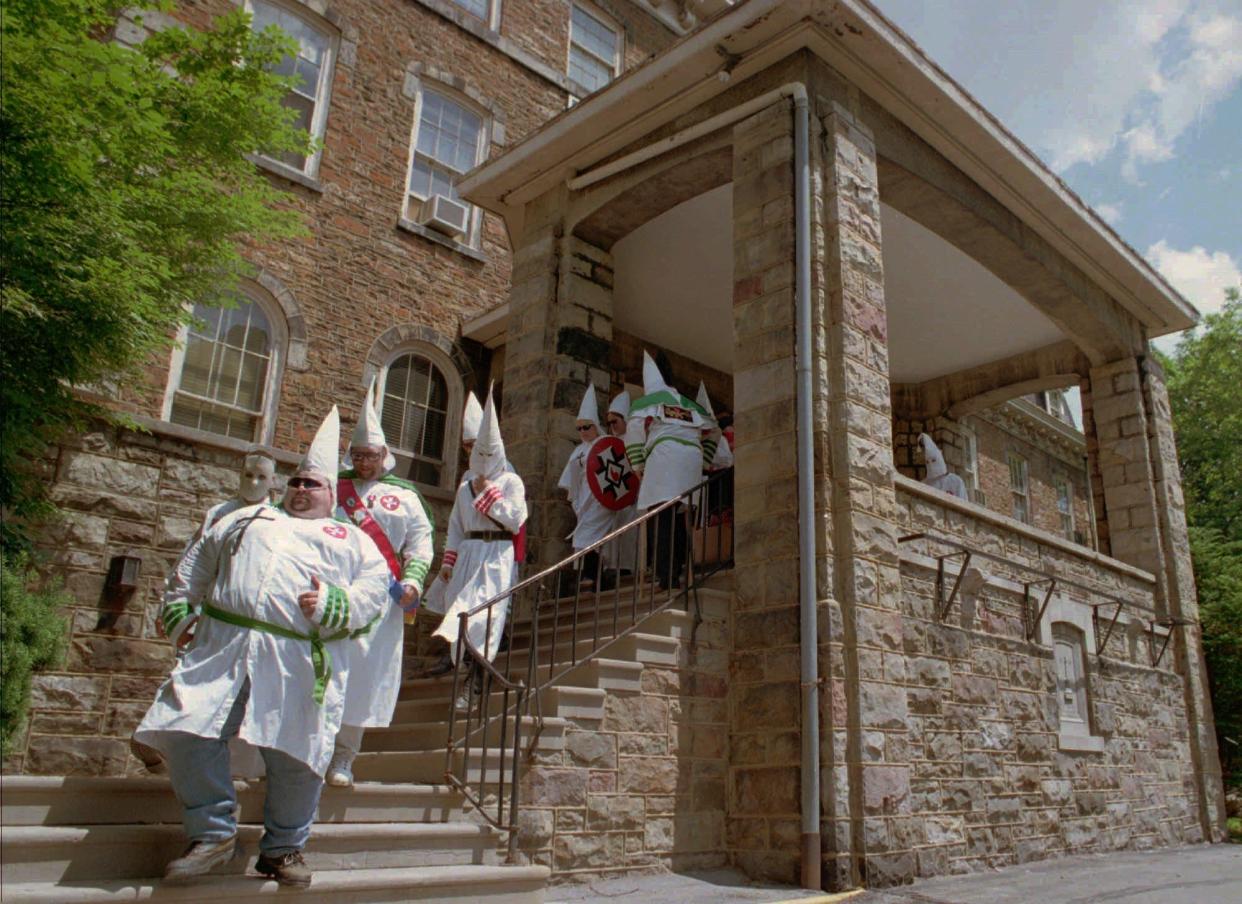 About 40 robed members of the Ku Klux Klan walk down the steps of Highland Hall, an annex of the Blair County courthouse, in Hollidaysbug, Pennsylvania, on June 15, 1996. Klan members traded slurs and insults with residents opposed to their white supremacist views. The verbal exchanges stopped short of violence, due largely to a full turnout by police during the Klan's hour-long rally in this central Pennsylvania town.