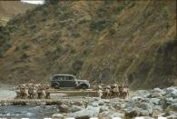 'Porters transport a car on long poles across a stream.' (Volkmar Wentzel/The National Geographic/Christie’s Images) <br> <br> <a href="https://www.christies.com/services/publications/browse-ecatalogues.aspx" rel="nofollow noopener" target="_blank" data-ylk="slk:Click here to see the full collection at Christie's;elm:context_link;itc:0;sec:content-canvas" class="link ">Click here to see the full collection at Christie's</a>