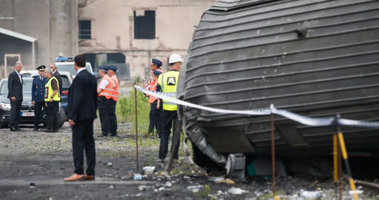 King Philippe of Belgium (L) looks at the scene of a train collision between a freight train and a passengers train on the line between Liege and Namur, in Saint-Georges-sur-Meuse on June 6, 2016