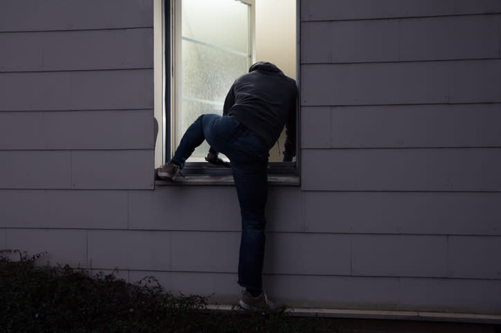 A man climbing into a window