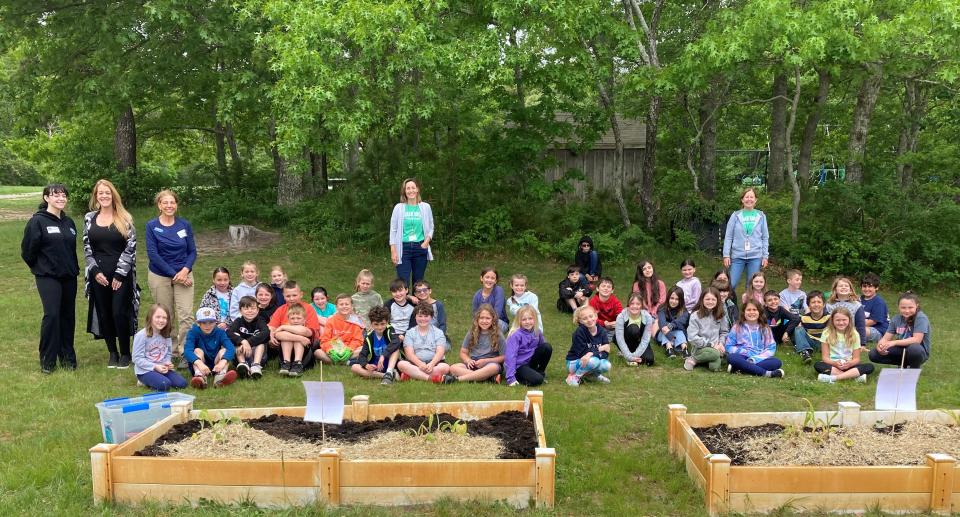 Third graders at Indian Brook plant vegetables in the school's raised bed garden.