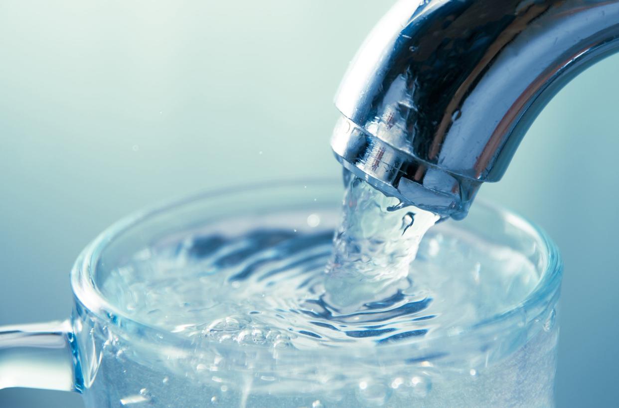 close-up view of water flowing from tap into glass