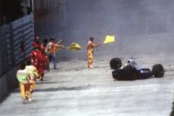 FILE- Race officials run toward Brazil's Aytron Senna after he crashed with his Williams-Renault during the San Marino F-1 Grand Prix in Imola Sunday May 1, 1994. The 30th anniversary of Ayrton Senna’s death is commemorated on Wednesday, May 1, 2024, with a memorial on the Imola track where he crashed during the 1994 San Marino Grand Prix. (AP Photo/File)