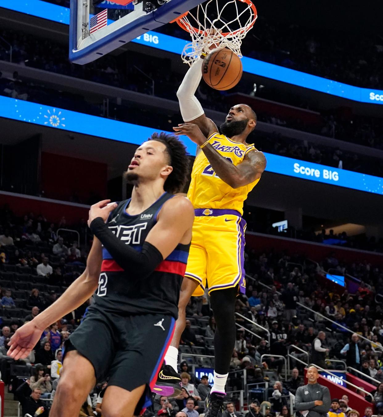 Lakers forward LeBron James dunks past Cade Cunningham during the second half of the Pistons' 133-107 loss on Wednesday, Nov. 29, 2023, at Little Caesars Arena.