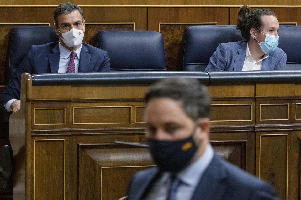 Vox party leader Santiago Abascal walks past Spain's Prime Minister Pedro Sanchez, left and 2nd Deputy Prime Minister Pablo Iglesias during a parliamentary session in Madrid, Spain, Thursday Oct. 22, 2020. Spanish Prime Minister Pedro Sanchez is facing a no-confidence vote in parliament brought by the nation's far-right Vox party. (Pablo Blazquez Dominguez/Pool via AP)