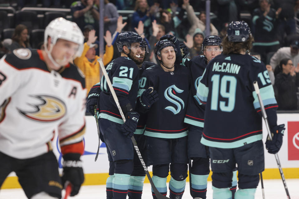 Seattle Kraken right wing Eeli Tolvanen, center, celebrates his goal with teammates as Anaheim Ducks right wing Jakob Silfverberg, left, looks on during the third period of an NHL hockey game Tuesday, March 7, 2023, in Seattle. The Kraken won 5-2. (AP Photo/Jason Redmond)