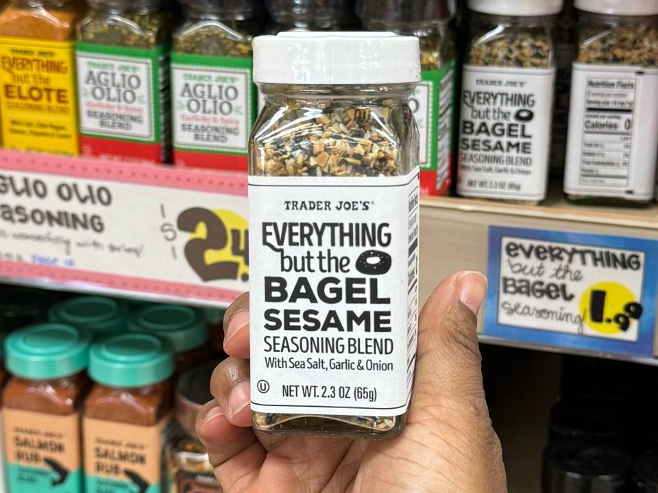 hand holding up a bottle of everything bagel seasoning at trader joes