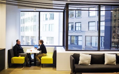 Employees sit in a booth at an office space in Boston - Credit: Adam Glanzman/Bloomberg