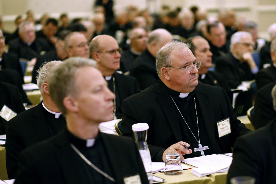 FILE - In this Nov. 13, 2017, file photo, then-Miami Auxiliary Bishop Peter Baldacchino sits with fellow members of the the United States Conference of Catholic Bishops during a session at the USCCB's annual fall meeting in Baltimore. Baldacchino, who is now a bishop in Las Cruces, N.M. announced Wednesday, April, 15, 2020, that the Las Cruces Diocese would "reopen" churches and lift the ban on public celebrations of Mass, a move believed to be a first by a diocese in the U.S. amid the coronavirus pandemic. (AP Photo/Patrick Semansky, File)