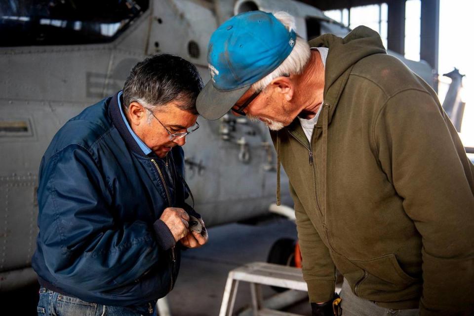 United States Air Force veterans Marcelo Paz, 69, of Chowchilla, left, and John Hogrefe, 71, of Modesto, right, inspect a handle to a Bell AH-1 Cobra attack helicopter inside Castle Air Museum’s restoration hanger in Atwater, Calif., on Wednesday, Jan. 12, 2022. According to Castle Air Museum Chief Executive Director Joe Pruzzo, both the Bell AH-1W Cobra attack helicopter and a SH-60B Seahawk helicopter were acquired from Hawaii in 2021. When ready, the aircraft will be displayed on the Castle Air Museum grounds along with dozens of other vintage aircraft.