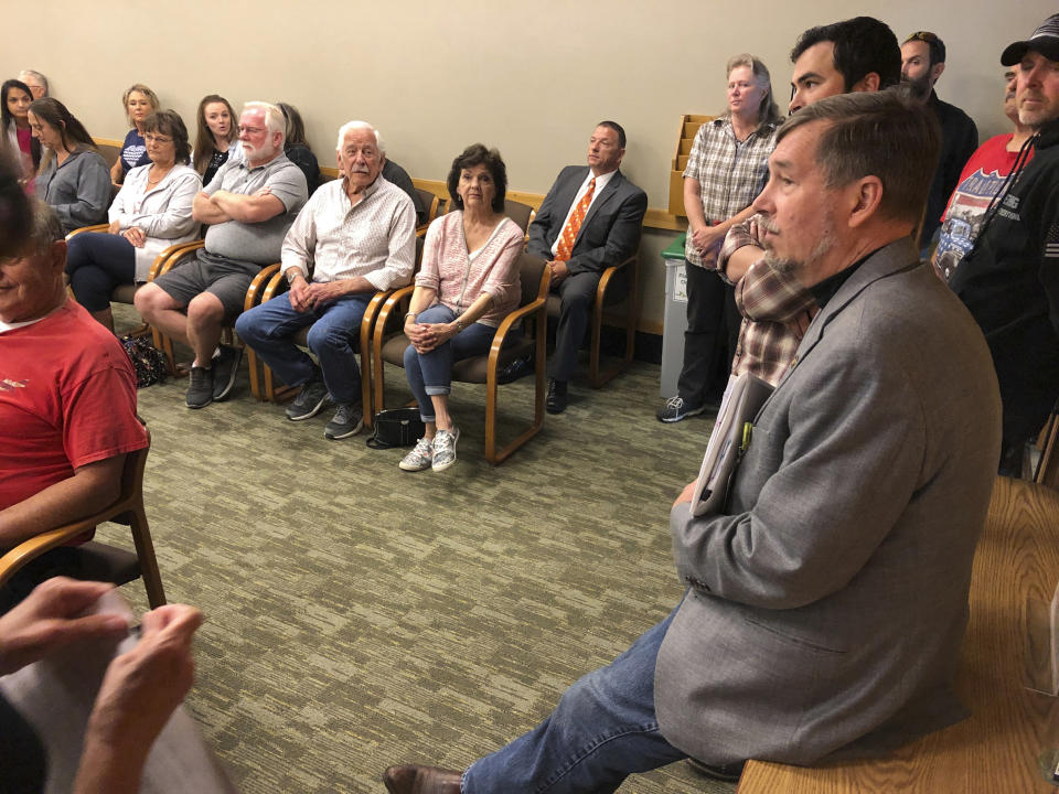 Sen. Brian Boquist, right, waits prior to a hearing at the state capital in Salem, Ore. on Monday, July 8, 2019. A special committee of the Oregon state Senate is holding a hearing over the lawmaker's comments he made during a Republican revolt over climate legislation. (AP Photo/Andrew Selsky)