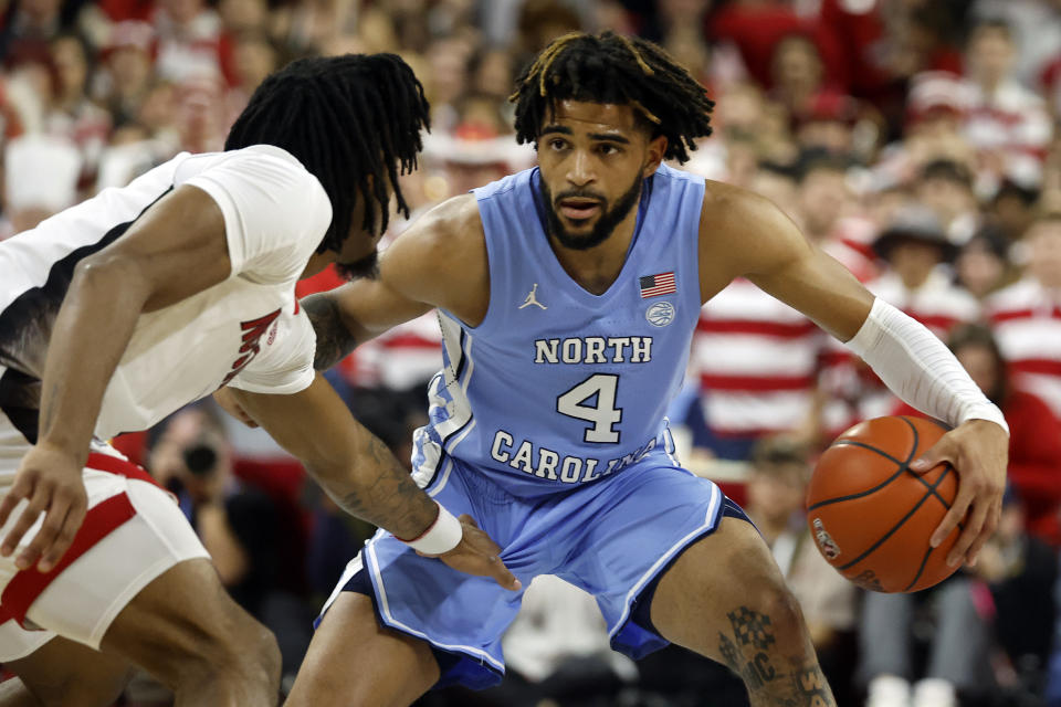 North Carolina's RJ Davis (4) controls the ball in front of North Carolina State's Jayden Taylor (1) during the first half of an NCAA college basketball game in Raleigh, N.C., Wednesday, Jan. 10, 2024. (AP Photo/Karl B DeBlaker)