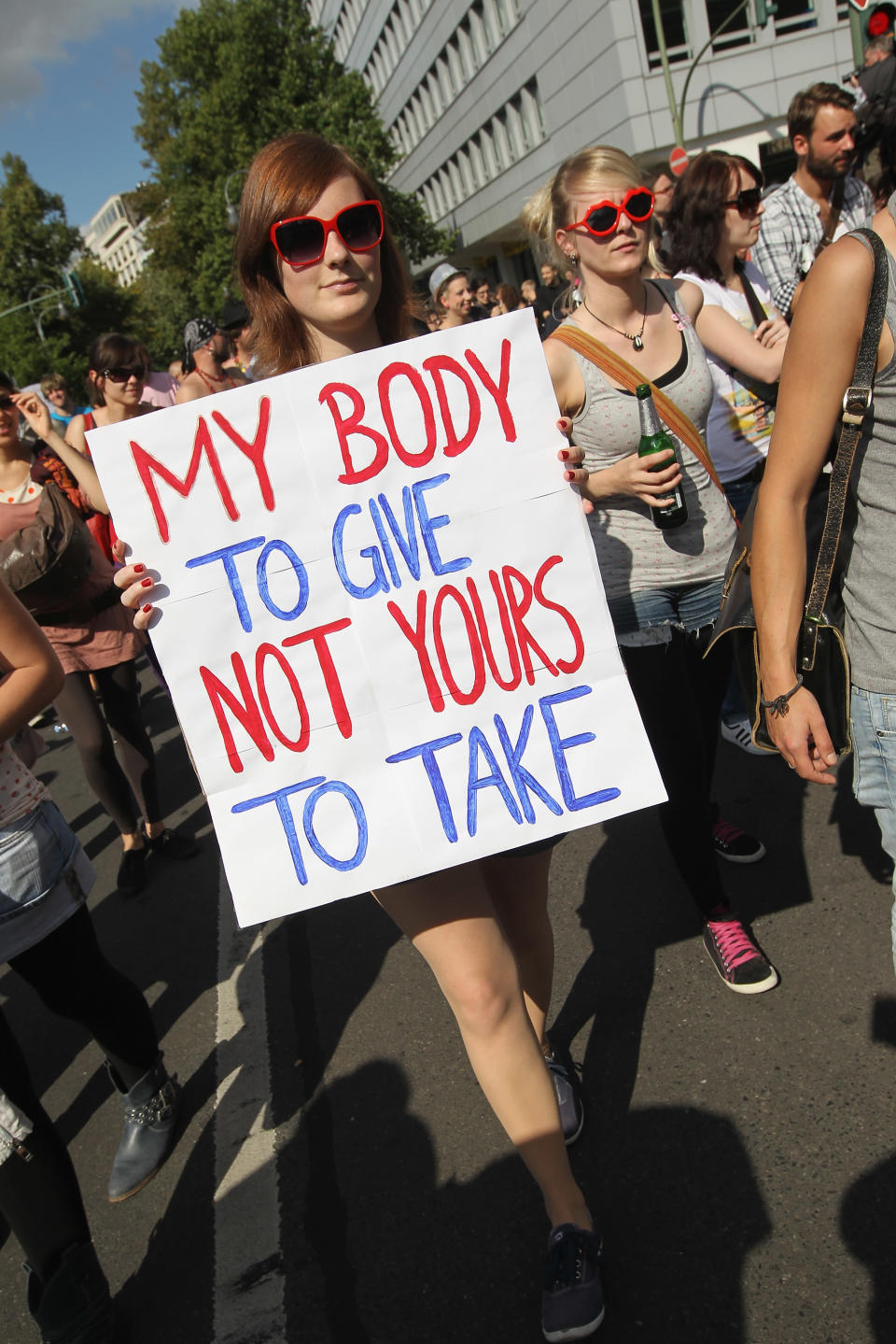 BERLIN, GERMANY - AUGUST 13: A young woman holding a sign that reads: "My Body To Give Not Yours To Take" participates in the "Slut Walk" march on August 13, 2011 in Berlin, Germany. Several thousand men and women turned out to protest against rape and a woman's right to her body. (Photo by Sean Gallup/Getty Images)